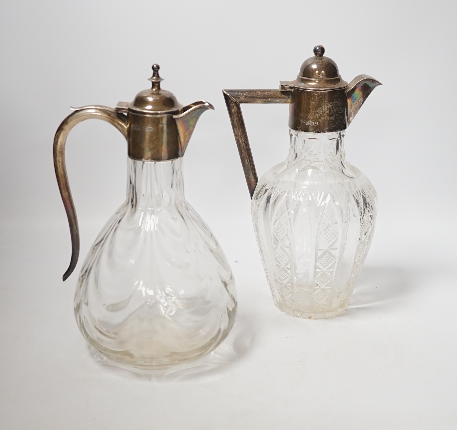 Two early 20th century silver mounted glass claret jugs, William Henry Leather, Birmingham, 1901 and William Aitken, Chester, 1901, tallest 24.2cm.